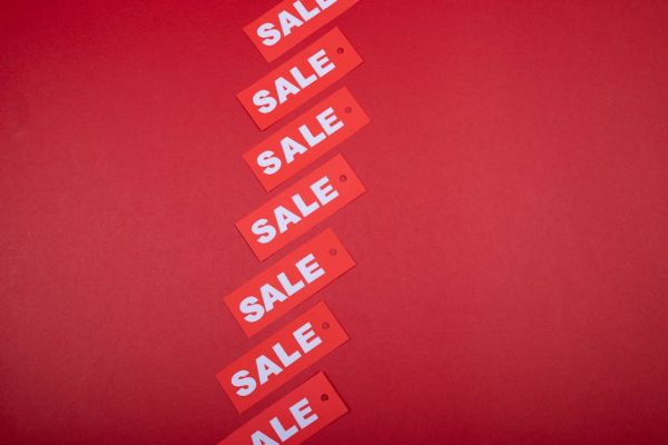Red sale tags aligned diagonally on a red background, perfect for retail promotions.