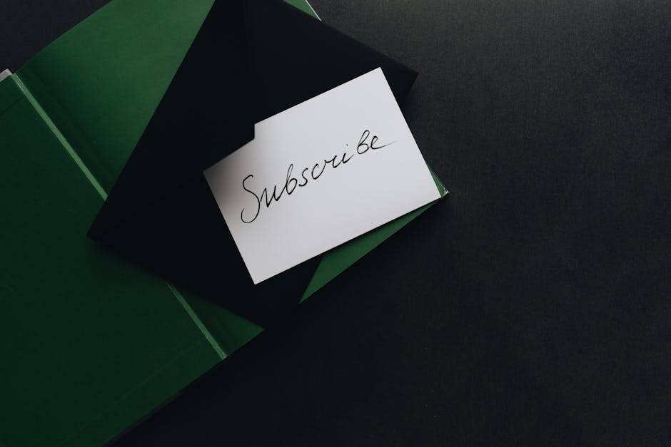 A minimalist image of a 'Subscribe' card in a green envelope on a dark background.