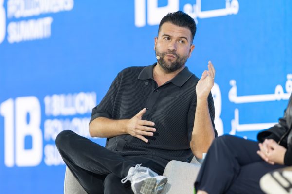 Man speaking on a panel with a blue background