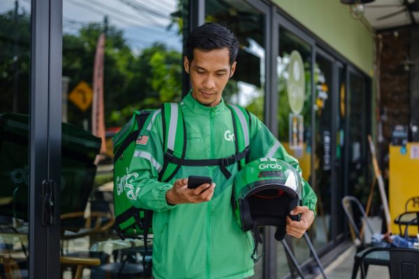 a man in a green jacket looking at his cell phone